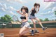 Two young women are playing tennis on a tennis court.