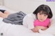 A woman laying on a bed holding a pink pillow.