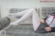 A woman laying on a couch with her legs crossed.