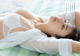 A woman laying on a bed wearing a white bra.