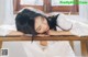 A woman laying on top of a wooden table.