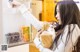 A woman holding a bag of food in front of a refrigerator.