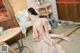 A woman in a pink dress is laying on a bed.