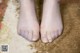 A close up of a person's bare feet on a rug.