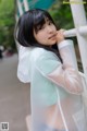 A woman in a white shirt leaning against a railing.